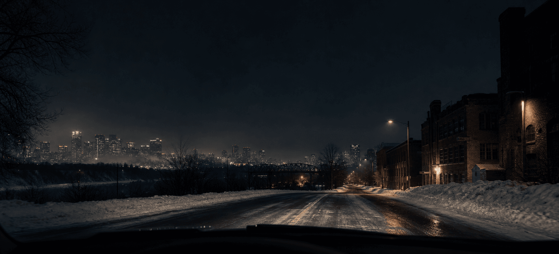 An empty Edmonton road receding beneath a cold night sky